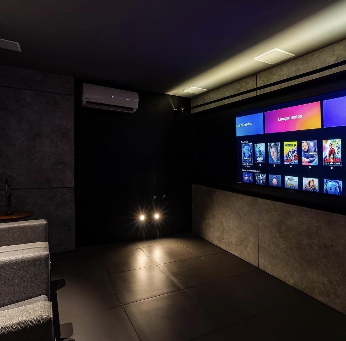 Tela de projeção de home theater residencial com sistema de som surround instalado nas paredes